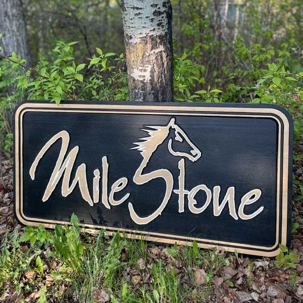 Custom CNC carved sign for local ranch 'Mile Stone,' featuring a sleek design with black, gold accents, and pops of white. The bold color contrast highlights the intricate carving, giving the sign a striking and elegant appearance.