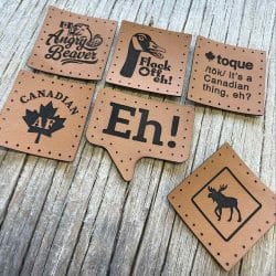 A collection of Canadian-themed faux leather patches, including designs like Angry Beaver, Flock Off, Toque, Canada AF, EH!, and Moose Crossing. Each patch is crafted from polyester-based faux leather with a brushed cotton backing, designed and made in a home studio.